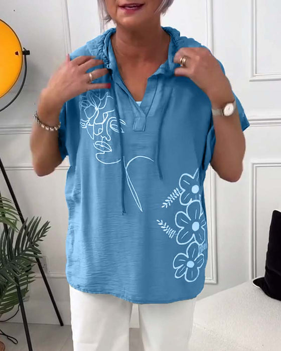 Lässige bluse mit kapuze und blumenmuster und kurzen ärmeln