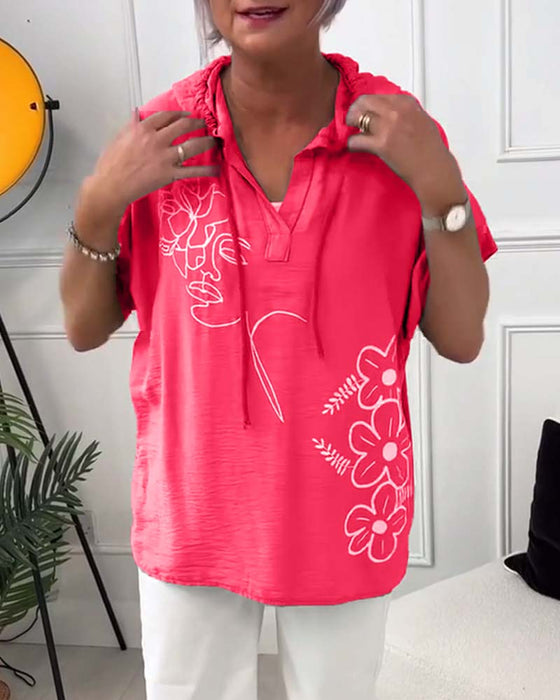 Lässige bluse mit kapuze und blumenmuster und kurzen ärmeln