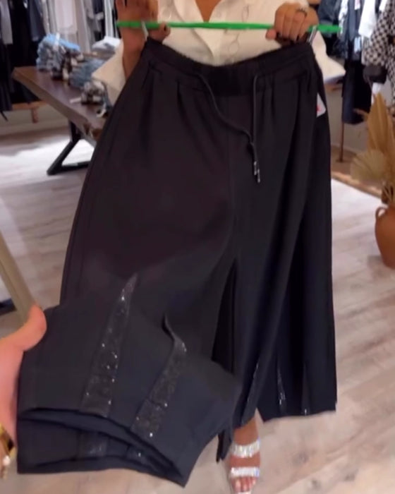 Lässige, einfarbige hose mit kordelzug und pailletten-patchwork