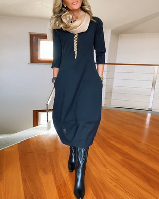 Elegantes einfarbiges kleid mit rundhalsausschnitt und tasche