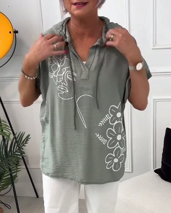 Lässige bluse mit kapuze und blumenmuster und kurzen ärmeln